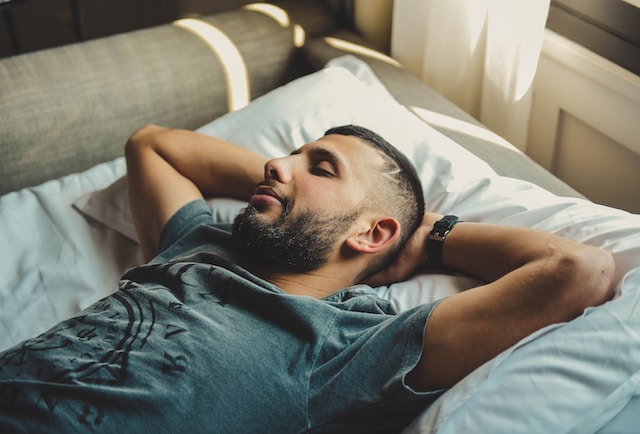 man laying in bed with his eyes closed